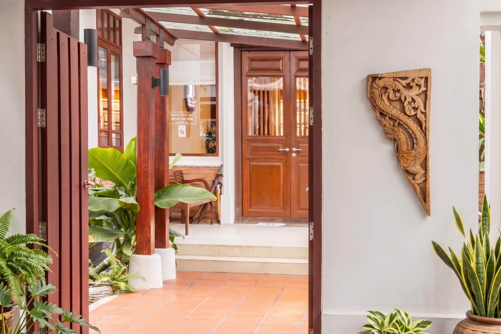 Healthi Life House entrance — private Thai villa with teak doors and Naga carving, Ekkamai 10 Bangkok